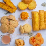 A spread of indian bakery snacks on a table including biscuits, puffs, rusks, and para
